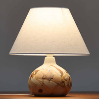 Soholm Keramik(スーホルム・セラミック)が手掛けたこちらのテーブルランプは、淡いグレーを基調にブラウンの流れるような釉薬模様が美しく広がる有機的な表情が魅力で、丸みを帯びた陶磁器のベースが空間にやさしい存在感をもたらす北欧ビンテージ品です。リネンシェードを透ける柔らかな灯りが落ち着いた雰囲気をつくり、ベッドサイドやリビングの間接照明として取り入れやすく、経年によって深まった色合いと一点物ならではの味わいを長く楽しめる一台です。