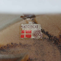 Soholm Keramik(スーホルム・セラミック)が手掛けたこちらのテーブルランプは、淡いグレーを基調にブラウンの流れるような釉薬模様が美しく広がる有機的な表情が魅力で、丸みを帯びた陶磁器のベースが空間にやさしい存在感をもたらす北欧ビンテージ品です。リネンシェードを透ける柔らかな灯りが落ち着いた雰囲気をつくり、ベッドサイドやリビングの間接照明として取り入れやすく、経年によって深まった色合いと一点物ならではの味わいを長く楽しめる一台です。