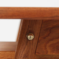 Poul M. Voltherがデザインし、FDB Moblerによって製作された片袖デスク。チーク材の天板と収納部、オーク材の脚部を組み合わせた構成に、真鍮の金具がさりげないアクセントを添える北欧ビンテージらしい一台です。幅160cmのゆとりあるサイズ感に対して、脚部や幕板は軽やかに設計されており、空間に圧迫感を与えません。片側に備えた引き出しユニットは、取り付けた状態でもスライドさせて位置調整が可能で、左右どちら側にも付け替えられる柔軟な構造となっています。さらに引き出しを取り外すことで、デスクとしてだけでなくダイニングテーブルとしても使用でき、暮らしの変化に合わせた使い方ができる点も魅力です。素材ごとの質感の違いと、経年により深みを増した木肌の表情が調和した、長く使い続けたくなるデザインです。