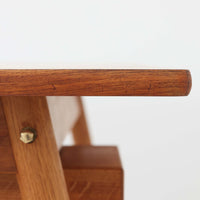 Poul M. Voltherがデザインし、FDB Moblerによって製作された片袖デスク。チーク材の天板と収納部、オーク材の脚部を組み合わせた構成に、真鍮の金具がさりげないアクセントを添える北欧ビンテージらしい一台です。幅160cmのゆとりあるサイズ感に対して、脚部や幕板は軽やかに設計されており、空間に圧迫感を与えません。片側に備えた引き出しユニットは、取り付けた状態でもスライドさせて位置調整が可能で、左右どちら側にも付け替えられる柔軟な構造となっています。さらに引き出しを取り外すことで、デスクとしてだけでなくダイニングテーブルとしても使用でき、暮らしの変化に合わせた使い方ができる点も魅力です。素材ごとの質感の違いと、経年により深みを増した木肌の表情が調和した、長く使い続けたくなるデザインです。