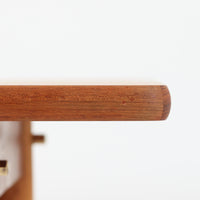 Poul M. Voltherがデザインし、FDB Moblerによって製作された片袖デスク。チーク材の天板と収納部、オーク材の脚部を組み合わせた構成に、真鍮の金具がさりげないアクセントを添える北欧ビンテージらしい一台です。幅160cmのゆとりあるサイズ感に対して、脚部や幕板は軽やかに設計されており、空間に圧迫感を与えません。片側に備えた引き出しユニットは、取り付けた状態でもスライドさせて位置調整が可能で、左右どちら側にも付け替えられる柔軟な構造となっています。さらに引き出しを取り外すことで、デスクとしてだけでなくダイニングテーブルとしても使用でき、暮らしの変化に合わせた使い方ができる点も魅力です。素材ごとの質感の違いと、経年により深みを増した木肌の表情が調和した、長く使い続けたくなるデザインです。