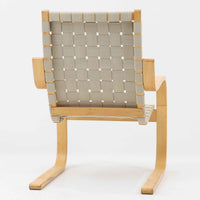 Alvar Aaltoがデザインし、Artekより製作されたNo.406アームチェアです。しなやかな曲線を描くバーチ材の成形フレームが特徴で、浮遊感のあるフォルムと軽やかな佇まいが空間に北欧らしい美しさをもたらします。本品は1996年製の個体で、ビンテージならではの雰囲気をお楽しみいただけます。座面と背もたれにはウェビングテープが張られ、適度な弾力と通気性の良い快適な座り心地を実現。アアルトの有機的なデザイン思想が感じられる一脚で、リビングやラウンジでの寛ぎの時間を彩るビンテージチェアです。