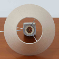 Nils Thorsson(ニルス・トールソン)がRoyal Copenhagen(ロイヤルコペンハーゲン)のために手掛けた「BACA」シリーズのテーブルランプは、繊細な線描と象徴的なモチーフが幾何学的に配置された陶磁器ベースが特徴で、手仕事ならではの奥行きあるブラウンの釉調がビンテージとしての存在感を高めています。上下で形状が切り替わる立体的な構造が光を受けて表情を変え、リネンシェードを通した柔らかな灯りが空間に落ち着いた陰影を添えます。高さ36cmの扱いやすいサイズで、リビングや寝室のサイドテーブルにもよく馴染み、北欧デザインの芸術性と実用性を兼ね備えた一台です。