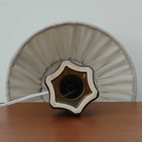 Einar JohansenがSoholm Keramik(スーホルム・セラミック)のためにデザインしたモデル1031は、深みのあるブルーの釉薬と立体的な面取りが織りなす陰影が美しい陶磁器ベースが特徴で、上部のマットな質感との対比がモダンで彫刻的な存在感を放つ北欧ビンテージ品です。プリーツシェードを透ける柔らかな灯りが落ち着いた雰囲気をつくり、ベッドサイドやリビングのアクセント照明として取り入れやすく、経年で深まった釉薬の表情が一点物ならではの魅力を一層引き立てています。