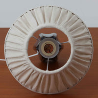 Einar JohansenがSoholm Keramik(スーホルム・セラミック)のためにデザインしたモデル1031は、深みのあるブルーの釉薬と立体的な面取りが織りなす陰影が美しい陶磁器ベースが特徴で、上部のマットな質感との対比がモダンで彫刻的な存在感を放つ北欧ビンテージ品です。プリーツシェードを透ける柔らかな灯りが落ち着いた雰囲気をつくり、ベッドサイドやリビングのアクセント照明として取り入れやすく、経年で深まった釉薬の表情が一点物ならではの魅力を一層引き立てています。