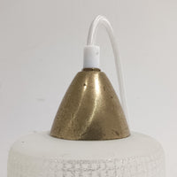 繊細なテクスチャーが施されたガラスシェードと、上部にあしらわれた真鍮パーツが上品に調和した直径11cmの小ぶりなペンダントライトで、柔らかい光がガラス越しに拡散し、空間に温かみのある雰囲気をもたらす北欧ビンテージ品です。控えめなサイズながら経年で深まった真鍮の風合いが個性を引き立て、玄関や洗面、キッチンカウンターなど小空間のアクセント照明として取り入れやすいデザインとなっています。クラフト感のあるガラスの質感が灯りに心地よい揺らぎを生み、単体でも複数灯でも美しくコーディネートできる点も魅力です。