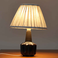 Einar JohansenがSoholm Keramikのために手掛けたモデル「1052」は、濃淡のある深いブルーグラデーションと面取りを施した立体的なフォルムが美しく、上部のマットな質感とのコントラストが上品な存在感を生む北欧ビンテージのテーブルランプです。柔らかく広がるリネンシェードの灯りが陰影豊かな陶肌をやさしく照らし、リビングや寝室のアクセントとして取り入れやすく、経年で深まった釉薬の表情が一点物ならではの味わいを引き立てています。