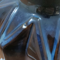 Einar JohansenがSoholm Keramikのために手掛けたモデル「1052」は、濃淡のある深いブルーグラデーションと面取りを施した立体的なフォルムが美しく、上部のマットな質感とのコントラストが上品な存在感を生む北欧ビンテージのテーブルランプです。柔らかく広がるリネンシェードの灯りが陰影豊かな陶肌をやさしく照らし、リビングや寝室のアクセントとして取り入れやすく、経年で深まった釉薬の表情が一点物ならではの味わいを引き立てています。