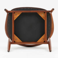 Kai Kristiansenがデザインし、Magnus Olesenが製作したTrojaアームチェアです。アフロモシア材の滑らかな木肌と深みのある色合いが美しく、背からアームへと一体で削り出されたフレームが身体をやさしく包み込みます。わずかに湾曲した笠木や細身の脚部が軽快な印象を与え、立ち座りの動作も自然。張り替え済みの座面は快適な掛け心地を備え、ダイニングや書斎空間に北欧ビンテージならではの気品と造形美をもたらす一脚です。ロゴは、デンマークの家具販売店(小売店)である Brdr. Ellehuus(エルフース兄弟店) のものです。