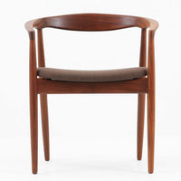 Kai Kristiansenがデザインし、Magnus Olesenが製作したTrojaアームチェアです。アフロモシア材の滑らかな木肌と深みのある色合いが美しく、背からアームへと一体で削り出されたフレームが身体をやさしく包み込みます。わずかに湾曲した笠木や細身の脚部が軽快な印象を与え、立ち座りの動作も自然。張り替え済みの座面は快適な掛け心地を備え、ダイニングや書斎空間に北欧ビンテージならではの気品と造形美をもたらす一脚です。ロゴは、デンマークの家具販売店(小売店)である Brdr. Ellehuus(エルフース兄弟店) のものです。