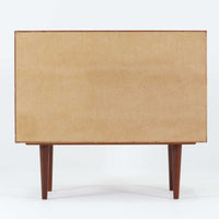 Kai Kristiansenがデザインし、Feldballes Mobelfabrikが製作した幅86cmの小ぶりなボードです。チーク材の美しい木目を活かした端正な箱型フォルムに、丸い引き手付きの引き戸がアクセントを添えます。内部には棚とトレー収納を備え、書類や小物を整理しやすい実用的な構造。すらりと伸びる脚部が軽やかさを演出し、限られた空間にも取り入れやすいサイズ感です。経年により深みを増した木肌が、北欧ビンテージならではの温もりと存在感を感じさせます。