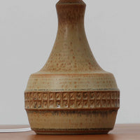 Soholm Keramik(スーホルム・セラミック)製のテーブルランプです。落ち着いたブラウンの陶磁器ボディに幾何学模様の装飾が施され、シンプルながらも存在感のあるデザインが魅力です。高さ38cmと扱いやすいサイズ感で、リビングや寝室のサイドテーブルに心地よい灯りを添えてくれます。北欧ビンテージならではの温かみある質感が、空間に柔らかな雰囲気をもたらします。