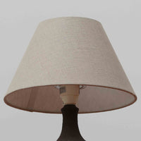 Chris HaslevがJetiのために手掛けたこちらのテーブルランプは、太陽を思わせるレリーフ模様をまとった陶器ベースと、素朴な土肌と釉薬の濃淡が織りなす豊かな表情が魅力で、コンパクトながら存在感を放つ北欧ビンテージ品です。上部のマットな質感が造形を引き締め、リネンシェード越しに広がるあたたかな灯りが空間をやさしく包み込み、リビングやベッドサイドのアクセントとして取り入れやすい一台に仕上がっています。