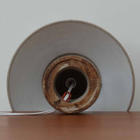 Axella製のこちらのテーブルランプは、素朴な陶土の質感と水平に重ねられた釉薬のグラデーションが生む落ち着いた佇まいが魅力で、ふくらみのある曲線的なベースと小ぶりなサイズ感が空間にさりげない温かみを添える北欧ビンテージ品です。リネンシェード越しに漏れる柔らかな灯りが陶肌の陰影をやさしく引き立て、デスクやベッドサイドなどにも取り入れやすく、経年で深まった素材の風合いが一点物ならではの味わいを感じさせてくれます。