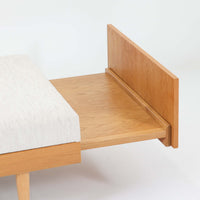 Ingmar Rellingがデザインし、EKORNESより発表されたSvane(スワン)デイベッドです。オーク材の明るく滑らかなフレームに、直線的な背もたれとすっきりとした脚部を組み合わせた端正な構造が特徴です。背もたれを上げると内部には帆布張りの収納部が備えられており、さらに背もたれを起こしてアーム部を伸ばすことでサイドテーブルとしても使用可能です。サイドテーブル部分に背クッションを載せることでベッドとしてもお使いいただけます。リビングやゲストルームなど多様な空間に適しており、張り替え済みのファブリックは上質な質感で空間にやわらかな印象を添えます。機能美と快適性を兼ね備えた、北欧ビンテージならではの名作です。