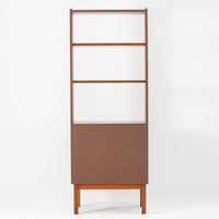 北欧ビンテージらしい機能性と造形美を備えたスリムシェルフです。チーク材のフレームにメタルを組み合わせた構造は、軽やかさと安定感を両立し、直線的で無駄のないフォルムが空間をすっきりと見せます。幅60cmの省スペース設計で、リビングや書斎、玄関まわりなど限られた場所にも取り入れやすく、書籍や小物、グリーンのディスプレイにも好適です。経年変化により深みを増したチーク材の色合いと、当時の実用性を重視した設計が、日常の暮らしに北欧らしい静かな存在感を添えます。