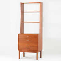 北欧ビンテージらしい機能性と造形美を備えたスリムシェルフです。チーク材のフレームにメタルを組み合わせた構造は、軽やかさと安定感を両立し、直線的で無駄のないフォルムが空間をすっきりと見せます。幅60cmの省スペース設計で、リビングや書斎、玄関まわりなど限られた場所にも取り入れやすく、書籍や小物、グリーンのディスプレイにも好適です。経年変化により深みを増したチーク材の色合いと、当時の実用性を重視した設計が、日常の暮らしに北欧らしい静かな存在感を添えます。