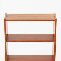 北欧ビンテージらしい機能性と造形美を備えたスリムシェルフです。チーク材のフレームにメタルを組み合わせた構造は、軽やかさと安定感を両立し、直線的で無駄のないフォルムが空間をすっきりと見せます。幅60cmの省スペース設計で、リビングや書斎、玄関まわりなど限られた場所にも取り入れやすく、書籍や小物、グリーンのディスプレイにも好適です。経年変化により深みを増したチーク材の色合いと、当時の実用性を重視した設計が、日常の暮らしに北欧らしい静かな存在感を添えます。