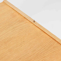 B. FridhagenがBodaforsのために手掛けたディスプレイシェルフは、端正なプロポーションと実用性を兼ね備えたスウェーデン製ビンテージ家具です。上部は抜け感のあるオープン棚構造で、器や書籍、オブジェなどを軽やかに飾ることができ、下部には4段の引き出しを備え、日常使いの収納にも対応します。オーク材ならではの明るく上品な木肌と、直線を基調とした構成が北欧らしい落ち着いた印象を生み、空間をすっきりとまとめてくれます。幅90cm、高さ122cmの小ぶりなサイズ感で、ダイニングやリビング、書斎など幅広いシーンに取り入れやすく、経年変化による木の表情も楽しめる一台です。