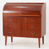 スウェーデン製のロールトップライティングビューロです。外装には深みのあるマホガニー材、脚部には明るいビーチ材を用い、ロールトップ扉には繊細な木目の表情が連なり、クラシカルで上質な佇まいを生み出しています。内部には小引き出しや仕切り棚が整然と配置され、書類や文具の整理に適した構造で、下部の引き出しは衣類や小物収納にも活躍します。幅90cmと取り入れやすいサイズ感で、書斎やリビングのワークスペースとしてもおすすめでき、経年変化による木肌の艶がビンテージならではの品格を空間にもたらします。