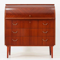 スウェーデン製のロールトップライティングビューロです。外装には深みのあるマホガニー材、脚部には明るいビーチ材を用い、ロールトップ扉には繊細な木目の表情が連なり、クラシカルで上質な佇まいを生み出しています。内部には小引き出しや仕切り棚が整然と配置され、書類や文具の整理に適した構造で、下部の引き出しは衣類や小物収納にも活躍します。幅90cmと取り入れやすいサイズ感で、書斎やリビングのワークスペースとしてもおすすめでき、経年変化による木肌の艶がビンテージならではの品格を空間にもたらします。