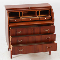 スウェーデン製のロールトップライティングビューロです。外装には深みのあるマホガニー材、脚部には明るいビーチ材を用い、ロールトップ扉には繊細な木目の表情が連なり、クラシカルで上質な佇まいを生み出しています。内部には小引き出しや仕切り棚が整然と配置され、書類や文具の整理に適した構造で、下部の引き出しは衣類や小物収納にも活躍します。幅90cmと取り入れやすいサイズ感で、書斎やリビングのワークスペースとしてもおすすめでき、経年変化による木肌の艶がビンテージならではの品格を空間にもたらします。