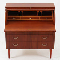 スウェーデン製のロールトップライティングビューロです。外装には深みのあるマホガニー材、脚部には明るいビーチ材を用い、ロールトップ扉には繊細な木目の表情が連なり、クラシカルで上質な佇まいを生み出しています。内部には小引き出しや仕切り棚が整然と配置され、書類や文具の整理に適した構造で、下部の引き出しは衣類や小物収納にも活躍します。幅90cmと取り入れやすいサイズ感で、書斎やリビングのワークスペースとしてもおすすめでき、経年変化による木肌の艶がビンテージならではの品格を空間にもたらします。