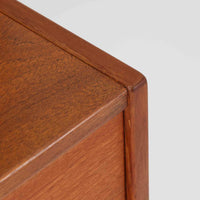 Nils Jonsson(ニールス・ヨンソン)がデザインし、Hugo Troeds(ヒューゴー・トロエッツ)社より製作されたDomi Monteシリーズのスリムシェルフです。良質なチーク材を用いた端正なキャビネットとオープンシェルフを組み合わせた構成で、収納力と見せるディスプレイ性を両立しています。直線を基調とした洗練されたフォルムと、引き出しに刻まれた繊細な手掛けが北欧らしい上品さを演出し、リビングや書斎、ダイニング収納としても活躍します。経年変化によって深みを増した木肌から、当時の職人技とビンテージならではの存在感が感じられる一台です。