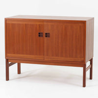 スウェーデンのデザイナー、カール・ヨハンソンによるデザイン、Bogaryds Mobler社製のチークキャビネットです。直線的なフォルムの中に、角の丸みや丁寧に仕上げられた框扉が柔らかさを添えています。チーク材の深みある色合いと美しい木目が上質な印象を与え、脚部を備えた軽快なデザインは空間に圧迫感を与えません。内部は棚板付きで収納力も高く、リビングや書斎など多用途に活躍する北欧ビンテージ家具です。