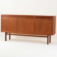 スウェーデン製のキッチンキャビネットです。美しいチーク材を使用し、幅181cmのゆとりあるサイズが空間に重厚感をもたらします。上部には浅めの引き出しを3杯、下部には扉収納を備え、内部には棚板が設けられており食器やカトラリー、リネン類まで整理しやすい実用的な構成。細身の脚部と幕板のラインが全体を軽やかに引き締め、直線的で端正な佇まいが北欧らしい機能美を感じさせます。経年により深みを増した木肌が、ビンテージならではの味わいを引き立てる一台です。