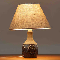 Chris HaslevがJetiのために手掛けたこちらのテーブルランプは、太陽を思わせるレリーフ模様をまとった陶器ベースと、素朴な土肌と釉薬の濃淡が織りなす豊かな表情が魅力で、コンパクトながら存在感を放つ北欧ビンテージ品です。上部のマットな質感が造形を引き締め、リネンシェード越しに広がるあたたかな灯りが空間をやさしく包み込み、リビングやベッドサイドのアクセントとして取り入れやすい一台に仕上がっています。