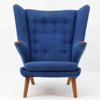 Hans J. Wegnerがデザインし、AP Stolenが製作したベアチェア AP-19 シングルソファです。包み込むように広がるハイバックと立体的なフォルムが特徴で、ゆったりと身体を預けられる快適な座り心地を生み出します。アーム先端のチーク材の滑らかな質感とオーク材の脚部による安定感のある構造が、美しいコントラストと上質な存在感を演出。張地内部にはビンテージ特有のスプリングが内包され、程よい弾力が寛ぎの時間をより豊かにします。空間の主役として北欧デザインの魅力を存分に味わえる一脚です。