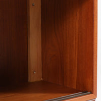 デンマークで製作されたチーク材のローボードです。幅100cmの小ぶりなサイズながら、温かみのある木目とシンプルな直線的フォルムが北欧らしい落ち着いた佇まいを演出します。前面には手掛け付きのスライド扉が備えられ、内部収納をすっきりと隠しながら使いやすさも確保。細身の脚部が軽やかな印象を与え、リビングや玄関、ベッドサイドなど様々な空間で活躍します。背板には壁掛け用の金具が取り付けられており、収納内部にはDIYによる木材の追加や小さな穴が見られますが、ビンテージ品ならではの味わいとして楽しめる一台です。