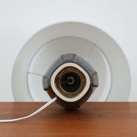 Soholm Keramikのモデル1025、Einar Johansenデザインによるデンマーク製ビンテージテーブルランプです。丸みを持たせた安定感のあるフォルムに、縦方向へ走る繊細なレリーフが美しい陰影を生み、深いネイビーブルーの釉薬が落ち着いた存在感を引き立てています。エイナー・ヨハンセンらしい端正で彫刻的な造形と、スーホルムならではの艶やかな焼き上がりが魅力。リネンシェード越しの柔らかな灯りが陶器の立体感を際立たせ、サイドテーブルやチェスト、ベッドサイドに上質な北欧空間を演出します。経年で深みを増した陶肌の表情と希少モデルならではのコレクション性も楽しめる一台です。