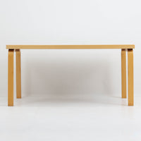 Artek(アルテック)社の「Table 81A」、Alvar Aalto(アルヴァ・アアルト)によるデザインのビンテージダイニングテーブルです。バーチ材を曲げて成形した象徴的なLレッグに、ホワイトのリノリウム天板を組み合わせた端正な佇まいが特徴。装飾を抑えたシンプルな構成ながら、柔らかな脚部の曲線にアアルトらしい造形美が表れています。幅150cmで食卓からワークテーブルまで使いやすく、時代を超えて空間に馴染む普遍的な魅力を備えています。