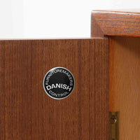 Hans J. Wegnerがデザインし、Ry Moblerが製作したディスプレイシェルフです。美しい木目をもつチーク材を主体に、内部や構造部にはオーク材、金具には真鍮を組み合わせた上質なつくりが魅力。上部のオープン棚は飾り棚として器やオブジェ、本を美しく見せ、下部の開き戸収納は細かい日用品や書類をすっきり隠して収納できます。直線的で端正なフォルムの中に、ウェグナーらしい丁寧な木工技術と素材の美しさが息づき、経年で深みを増した色艶が空間に格別の存在感を添える一品です。リビングや書斎、ショップ什器としてもおすすめです。