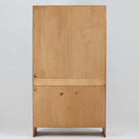 Hans J. Wegnerがデザインし、Ry Moblerが製作したディスプレイシェルフです。美しい木目をもつチーク材を主体に、内部や構造部にはオーク材、金具には真鍮を組み合わせた上質なつくりが魅力。上部のオープン棚は飾り棚として器やオブジェ、本を美しく見せ、下部の開き戸収納は細かい日用品や書類をすっきり隠して収納できます。直線的で端正なフォルムの中に、ウェグナーらしい丁寧な木工技術と素材の美しさが息づき、経年で深みを増した色艶が空間に格別の存在感を添える一品です。リビングや書斎、ショップ什器としてもおすすめです。