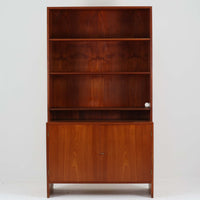 Hans J. Wegnerがデザインし、Ry Moblerが製作したディスプレイシェルフです。美しい木目をもつチーク材を主体に、内部や構造部にはオーク材、金具には真鍮を組み合わせた上質なつくりが魅力。上部のオープン棚は飾り棚として器やオブジェ、本を美しく見せ、下部の開き戸収納は細かい日用品や書類をすっきり隠して収納できます。直線的で端正なフォルムの中に、ウェグナーらしい丁寧な木工技術と素材の美しさが息づき、経年で深みを増した色艶が空間に格別の存在感を添える一品です。リビングや書斎、ショップ什器としてもおすすめです。