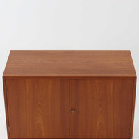 Hans J. Wegnerがデザインし、Ry Moblerが製作したディスプレイシェルフです。美しい木目をもつチーク材を主体に、内部や構造部にはオーク材、金具には真鍮を組み合わせた上質なつくりが魅力。上部のオープン棚は飾り棚として器やオブジェ、本を美しく見せ、下部の開き戸収納は細かい日用品や書類をすっきり隠して収納できます。直線的で端正なフォルムの中に、ウェグナーらしい丁寧な木工技術と素材の美しさが息づき、経年で深みを増した色艶が空間に格別の存在感を添える一品です。リビングや書斎、ショップ什器としてもおすすめです。