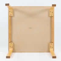 Alvar Aaltoがデザインし、Artekより製作された「81C」ダイニングテーブルです。バーチ材を用いたフレームに、天板には落ち着いた質感のリノリウムを組み合わせたシンプルで機能的なデザインが特徴。脚部にはアアルトを象徴するL字型の曲木構造が採用されており、軽やかで柔らかな印象を与えます。幅75cmの正方形サイズはダイニングはもちろんワークテーブルとしても使いやすく、日常の空間に北欧デザインの美しさと実用性をもたらすビンテージ家具です。本個体は、脚部の5枚レイヤー構造、1973年以降に採用されたプラスネジ、および天板裏の3段構成スタンプの仕様から、1973年~1990年代始めに掛けて製造されたと思われます。