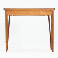 スウェーデンで製作されたコンソールテーブルです。天板にはチーク材、脚部にはオーク材を組み合わせ、温かみのある木目と落ち着いた色合いが北欧らしい上品な雰囲気を演出します。天板下には引き出しが備えられており、小物や文具などをすっきり収納できる実用的な構造。丸みを帯びた天板の角や細身のテーパー脚が軽やかな印象を与え、玄関やリビング、ベッドサイドなど限られたスペースにも収まりやすいサイズ感です。経年により深みを増した木部の表情が魅力の北欧ビンテージ家具です。