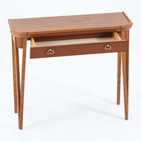 スウェーデンで製作されたコンソールテーブルです。天板にはチーク材、脚部にはオーク材を組み合わせ、温かみのある木目と落ち着いた色合いが北欧らしい上品な雰囲気を演出します。天板下には引き出しが備えられており、小物や文具などをすっきり収納できる実用的な構造。丸みを帯びた天板の角や細身のテーパー脚が軽やかな印象を与え、玄関やリビング、ベッドサイドなど限られたスペースにも収まりやすいサイズ感です。経年により深みを増した木部の表情が魅力の北欧ビンテージ家具です。