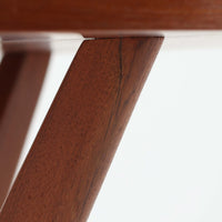 Holger Georg Jensen(ホルガー・ジョージ・イェンセン)がデザインし、Tonder Mobelvaerkが製造を手掛けた「Kubus」シリーズのセンターテーブルです。チーク材を用いた円形天板には中心から放射状に広がる美しい木目が表れ、中央へ向かって伸びる彫刻的な脚部と十字型のベースが印象的。直径78cmの程よいサイズで、ソファまわりにも取り入れやすく、経年を重ねたチークの深みある風合いと造形美を存分に楽しめる北欧ビンテージです。