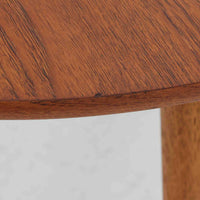 Hans J. Wegnerがデザインし、Andreas Tuckが製造を手掛けたAT8。チーク材の円形天板とオーク材の脚部を組み合わせ、異なる木材の表情を巧みに生かした一台です。直径98cmの伸びやかな天板を、外側へ緩やかに開く4本のテーパードレッグが軽快に支えるシンプルな構成で、素材とプロポーションの美しさが際立ちます。ソファを囲むリビングの主役として取り入れやすく、ウェグナーらしい端正な造形と年月を重ねた木部の風合いを味わえるビンテージ品です。