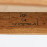 Soro Stolefabrik(ソロ・ストールファブリック)が手掛けた、チーク材とオーク材を組み合わせた北欧ビンテージのアームチェア。明るく美しい木目のオーク材を主体としたフレームに、深みのある色合いのチーク材をアームレストに使用し、異なる木材のコントラストが上品なアクセントを添えています。緩やかな曲線を描く背もたれには幾何学模様のファブリックを合わせ、柔らかな色合いの座面とともに落ち着いた雰囲気を演出。直線的な脚部や貫を組み合わせた構造には、北欧家具らしい機能美と丁寧な木工技術が感じられます。ダイニングや書斎の椅子としてはもちろん、リビングの一角に置くアクセントチェアとしてもおすすめの、温もりとビンテージならではの味わいを兼ね備えた一脚です。