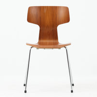 アルネ・ヤコブセンがデザインし、Fritz Hansenが製造した「T Chair」です。チーク材の成形合板による背座一体型のシェルは、背面上部を左右に広げた特徴的なシルエットと、身体に沿う緩やかな曲面が魅力。細身の金属脚との組み合わせが軽快で、ダイニングはもちろん、書斎や玄関のアクセントチェアにもおすすめです。美しい木目と時を重ねた風合い、合理的な構造に宿る北欧ビンテージらしい存在感を楽しめます。
