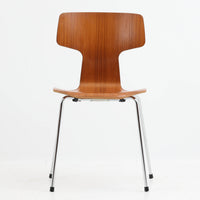アルネ・ヤコブセンがデザインし、Fritz Hansenが製造した「T Chair」です。チーク材の成形合板による背座一体型のシェルは、背面上部を左右に広げた特徴的なシルエットと、身体に沿う緩やかな曲面が魅力。細身の金属脚との組み合わせが軽快で、ダイニングはもちろん、書斎や玄関のアクセントチェアにもおすすめです。美しい木目と時を重ねた風合い、合理的な構造に宿る北欧ビンテージらしい存在感を楽しめます。