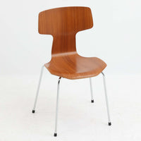 アルネ・ヤコブセンがデザインし、Fritz Hansenが製造した「T Chair」です。チーク材の成形合板による背座一体型のシェルは、背面上部を左右に広げた特徴的なシルエットと、身体に沿う緩やかな曲面が魅力。細身の金属脚との組み合わせが軽快で、ダイニングはもちろん、書斎や玄関のアクセントチェアにもおすすめです。美しい木目と時を重ねた風合い、合理的な構造に宿る北欧ビンテージらしい存在感を楽しめます。
