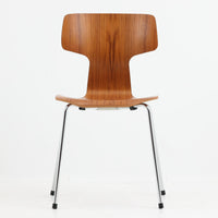 アルネ・ヤコブセンがデザインし、Fritz Hansenが製造した「T Chair」です。チーク材の成形合板による背座一体型のシェルは、背面上部を左右に広げた特徴的なシルエットと、身体に沿う緩やかな曲面が魅力。細身の金属脚との組み合わせが軽快で、ダイニングはもちろん、書斎や玄関のアクセントチェアにもおすすめです。美しい木目と時を重ねた風合い、合理的な構造に宿る北欧ビンテージらしい存在感を楽しめます。