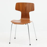 アルネ・ヤコブセンがデザインし、Fritz Hansenが製造した「T Chair」です。チーク材の成形合板による背座一体型のシェルは、背面上部を左右に広げた特徴的なシルエットと、身体に沿う緩やかな曲面が魅力。細身の金属脚との組み合わせが軽快で、ダイニングはもちろん、書斎や玄関のアクセントチェアにもおすすめです。美しい木目と時を重ねた風合い、合理的な構造に宿る北欧ビンテージらしい存在感を楽しめます。